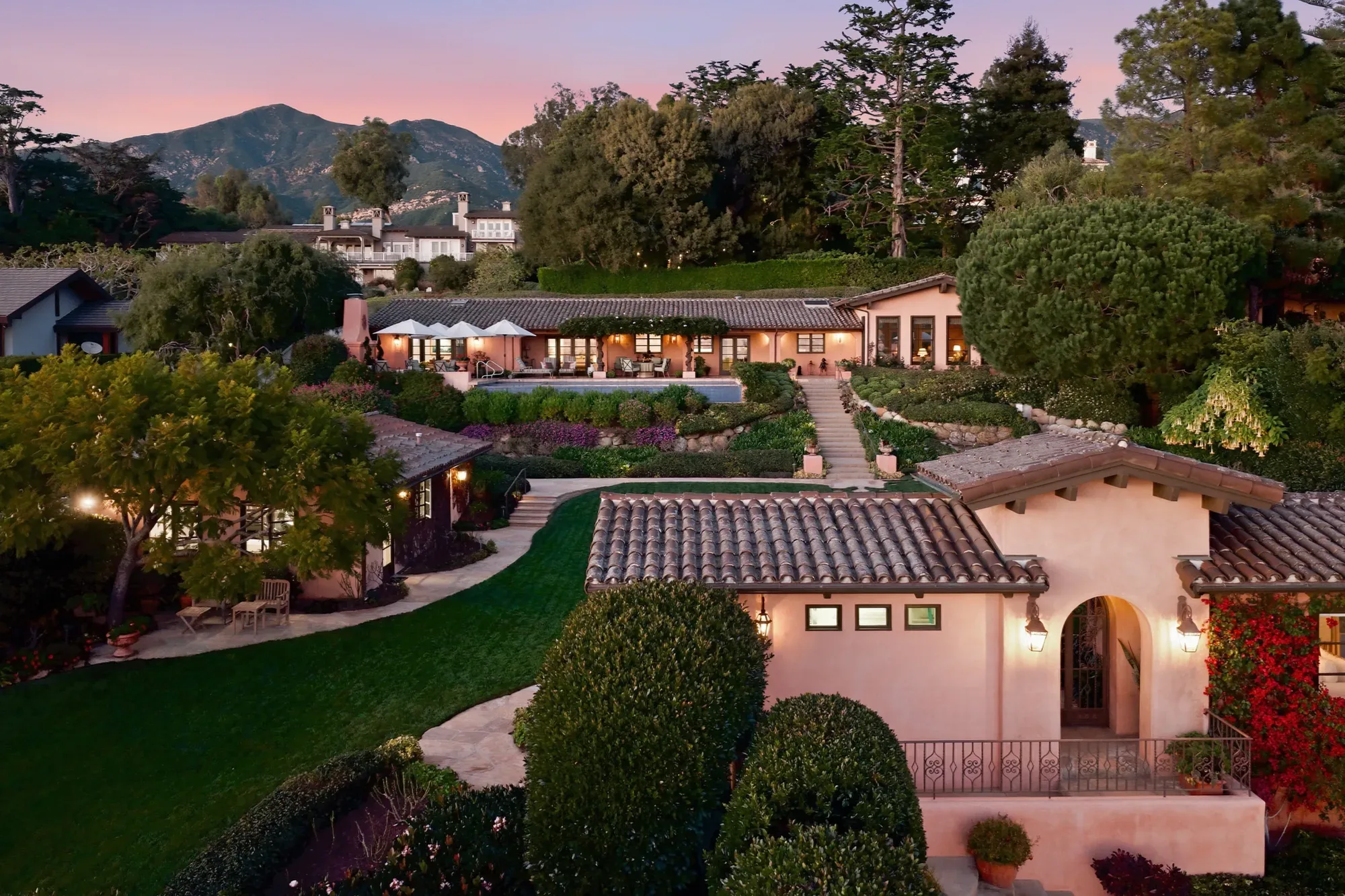 Twilight aerial of a Mediterranean estate with pool and gardens