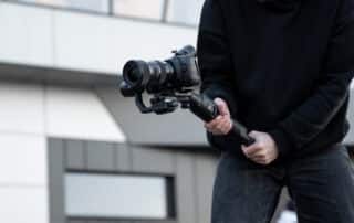 Videographer holding camera with gimbal for Cinematic Showing Videos, showcasing Drone-Enhanced Property Tours and creating Aerial Real Estate Showcases