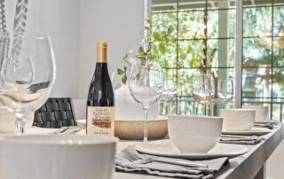 White table in a Montecito Airbnb listing, professionally photographed with a bottle of wine; image captured by Roto Flight's expert drone photography techniques.