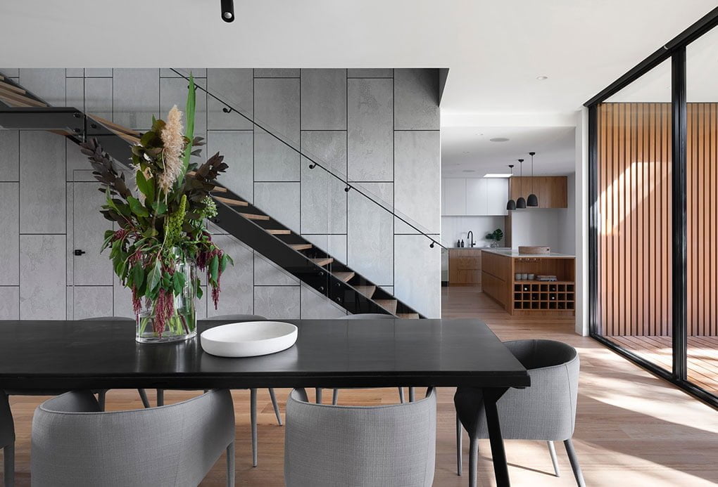 A modern dining room with a black table and chairs in a cozy home.
